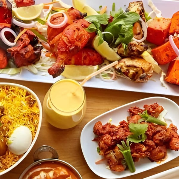 A vibrant spread of Indian dishes, including tandoori chicken, biryani, and a mango lassi.